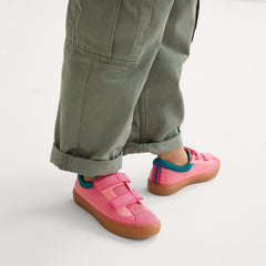 hover | A child modeling The Kids Strap Sneaker in Watermelon. 