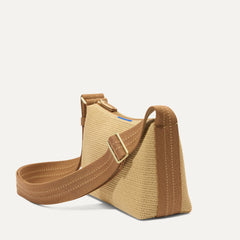 The Casual Crossbody in Brown Butter Raffia-Knit, shown from the side at an angle.