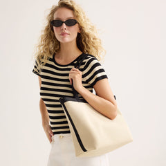 hover | Model holding The Lightweight Zip Tote in Black and White Raffia-Knit.