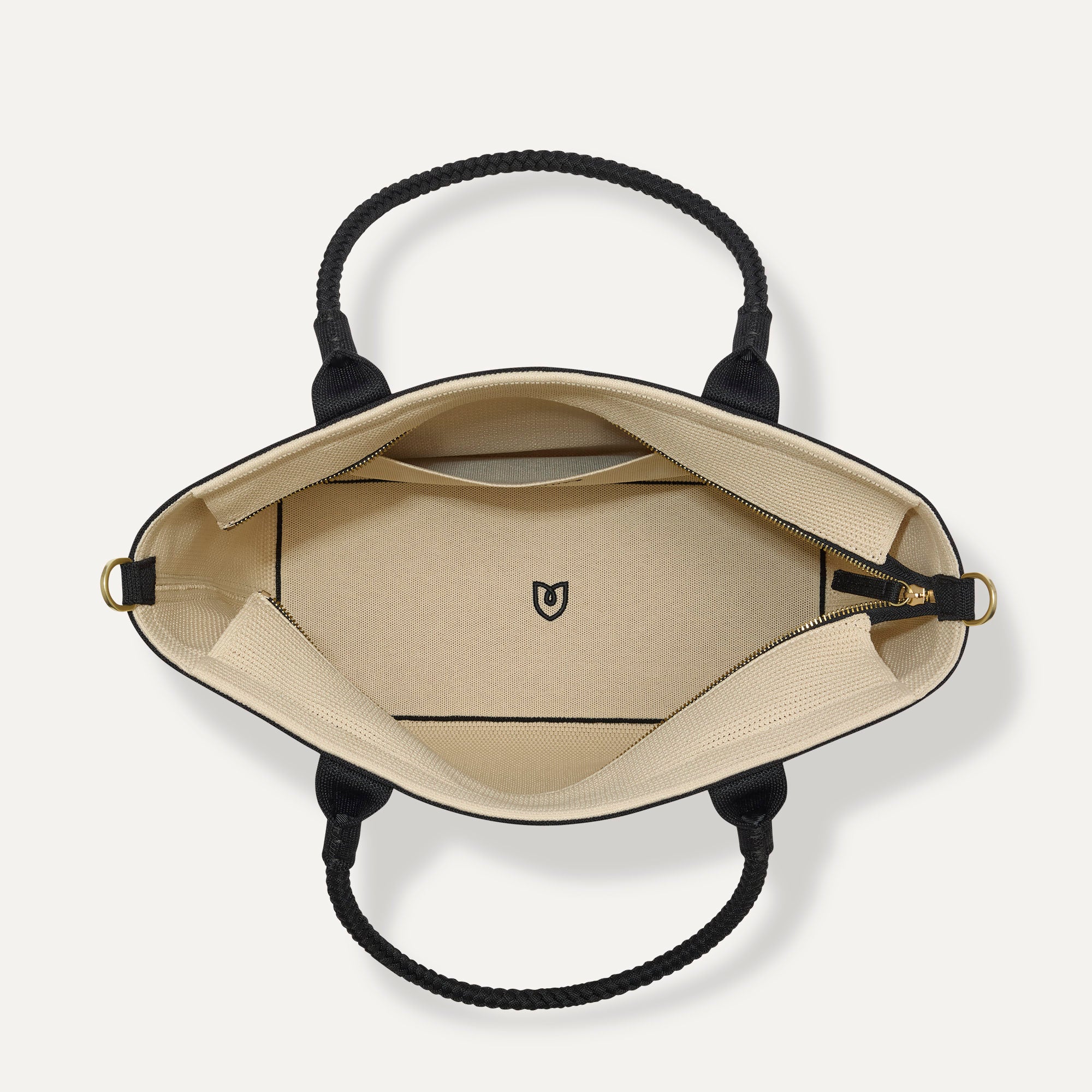 The Lightweight Zip Tote in Black and White Raffia-Knit, shown from above with the interior exposed.