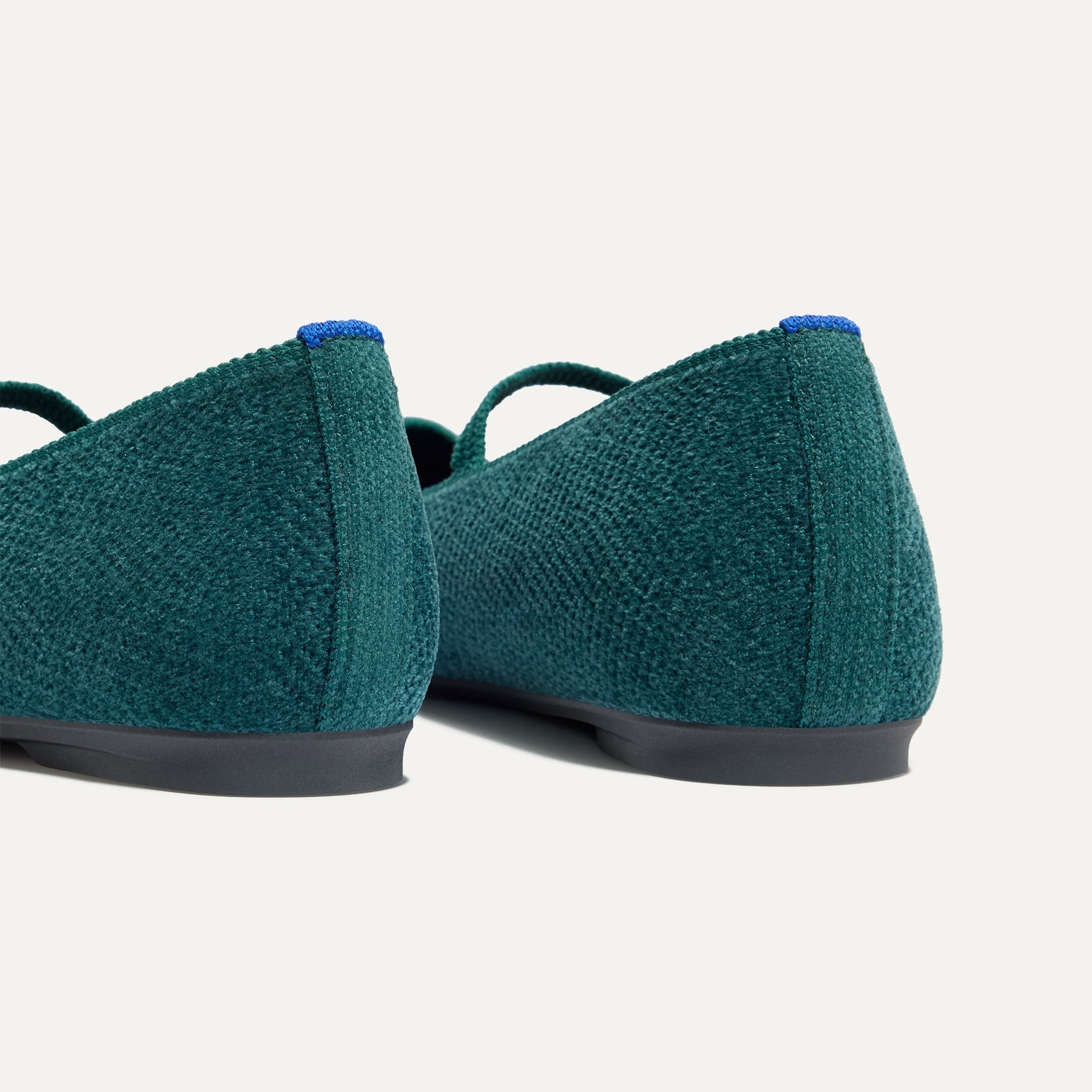 Close up of the heel of The Max Square Mary Jane in ReVelvet™ Everglade, with Rothy's signature blue halo.