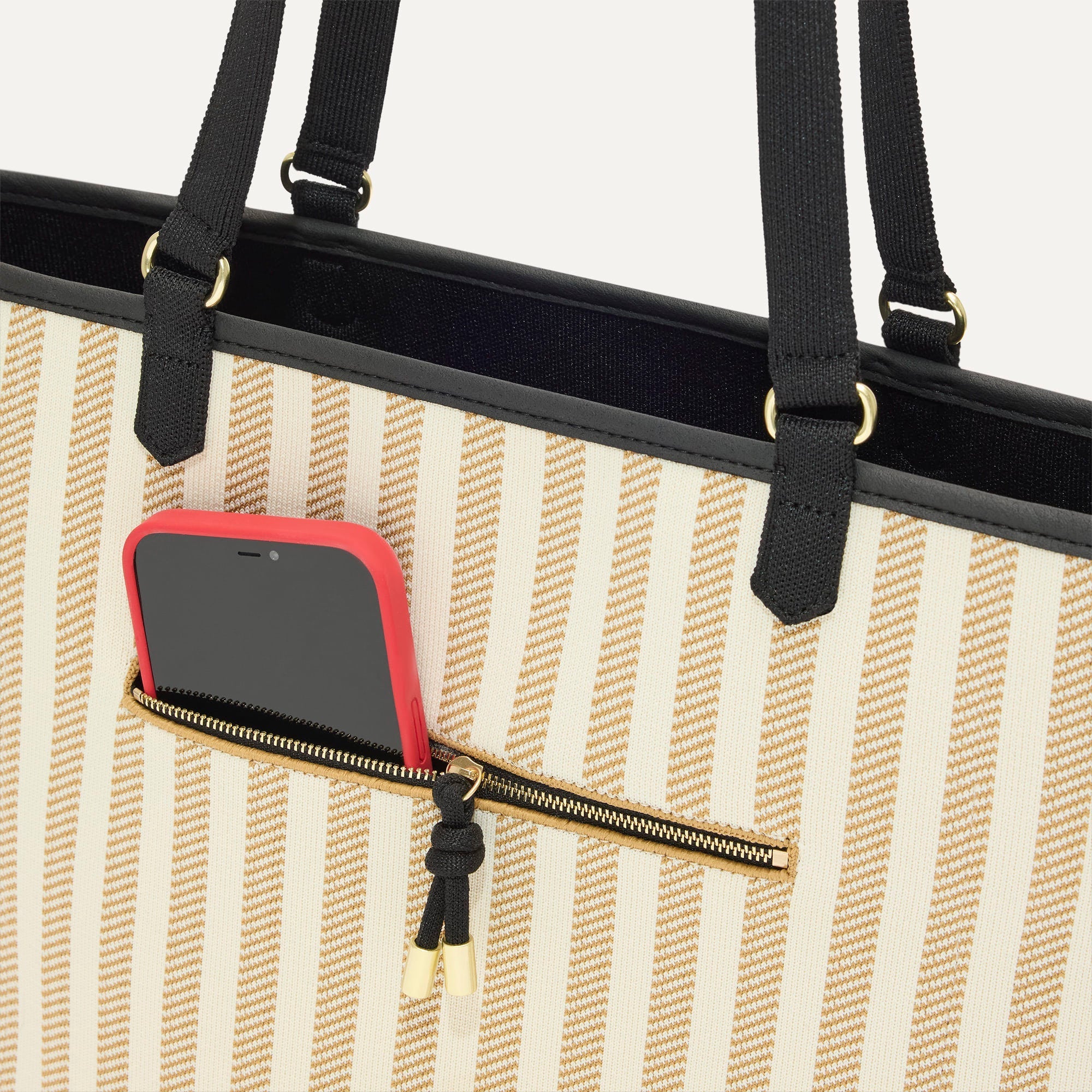 A closeup of The Two-Way Tote in Sandbar, focusing on the exterior zip pocket.