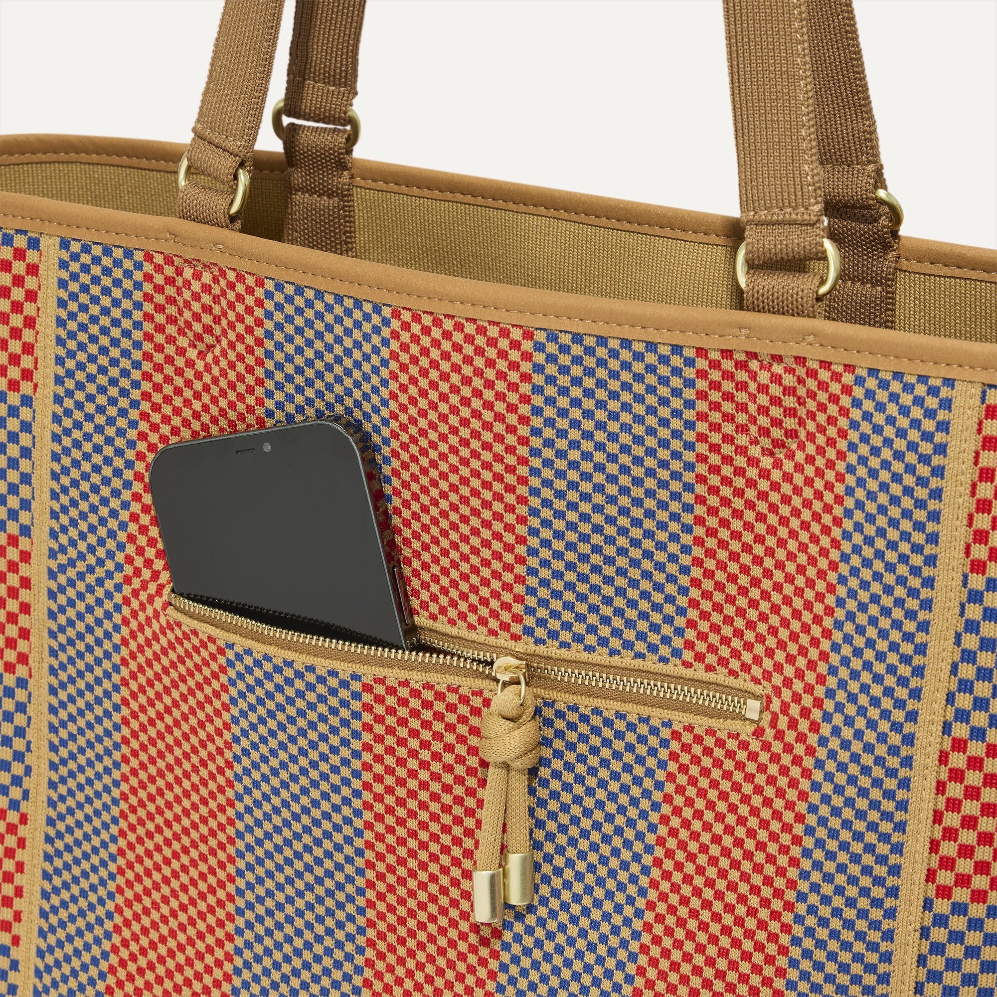 A closeup of The Two-Way Tote in Sienna, focusing on the exterior zip pocket.