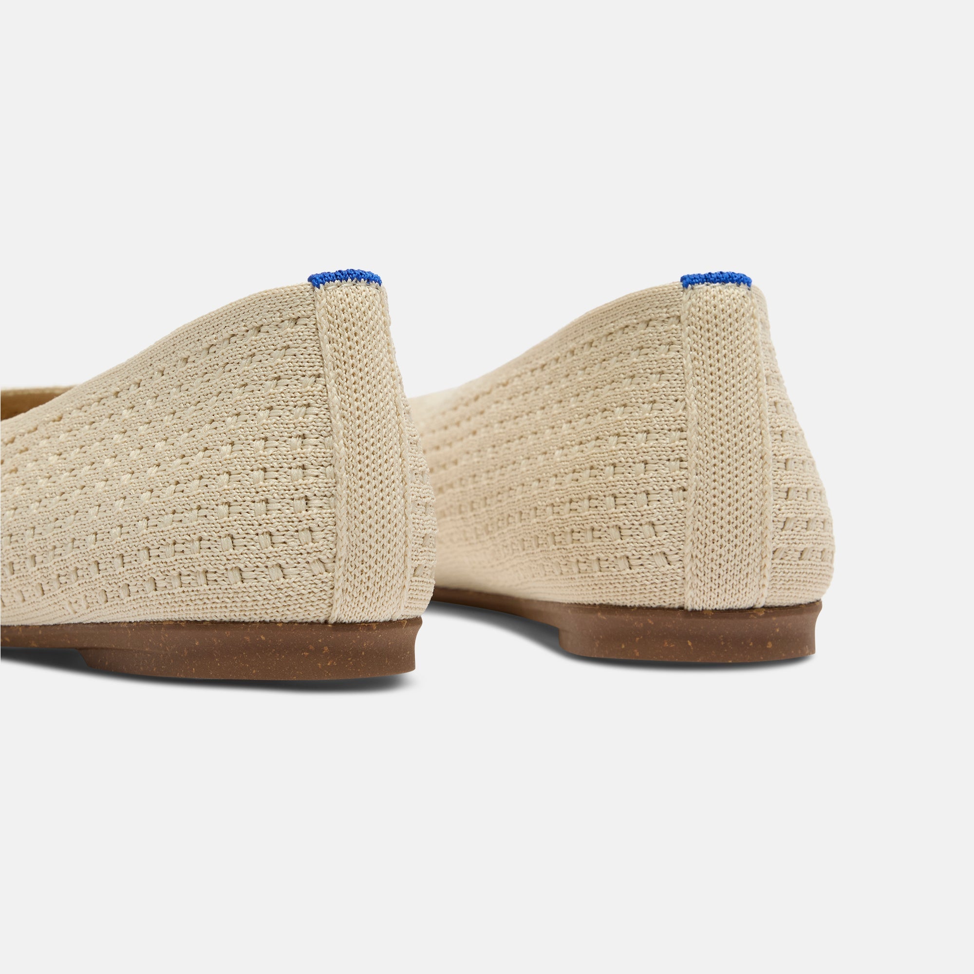 Close up of the heel of The Max Square Ballerina in Off White Mesh with Rothy's signature blue halo.