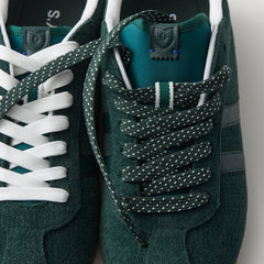 Overlay:: Extra pair of laces included—swap for a new look anytime. | Alt:: Close up of the top of The Ivy Sneaker in ReVelvet Evergreen, showing different lace choices.