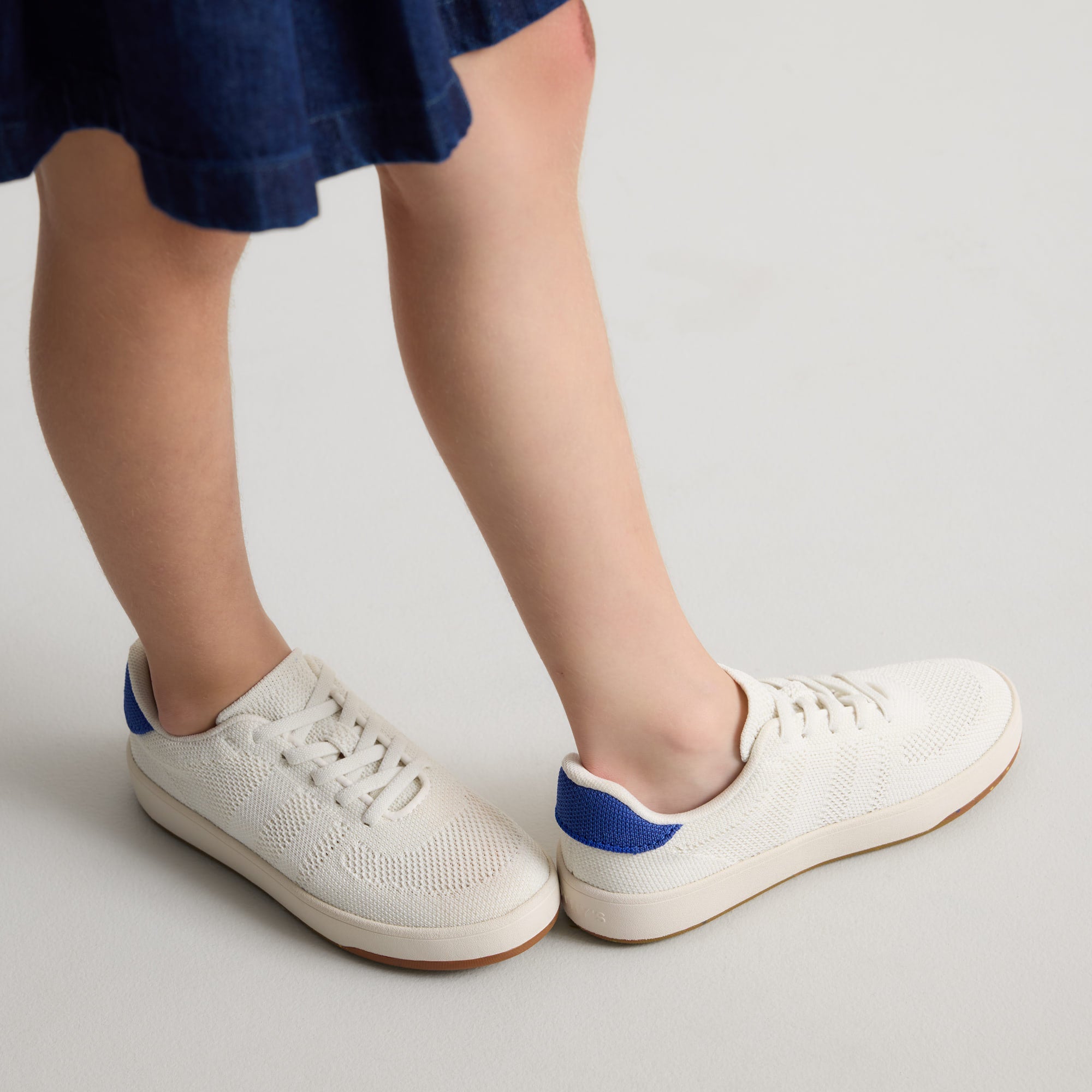 hover | A child modeling The Kids Stretch Sneaker in Turbo.