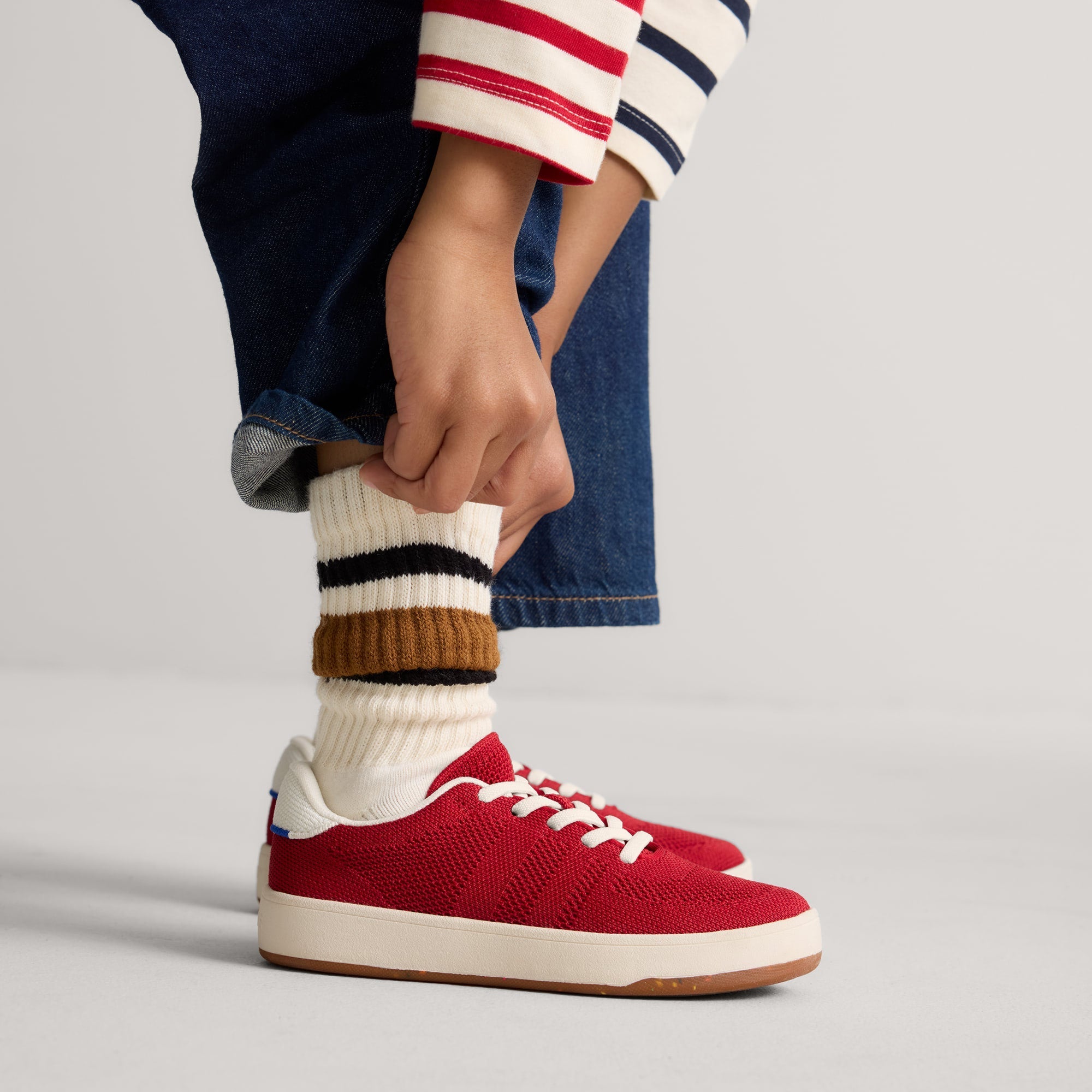 hover | A child modeling The Kids Stretch Sneaker in Firecracker.