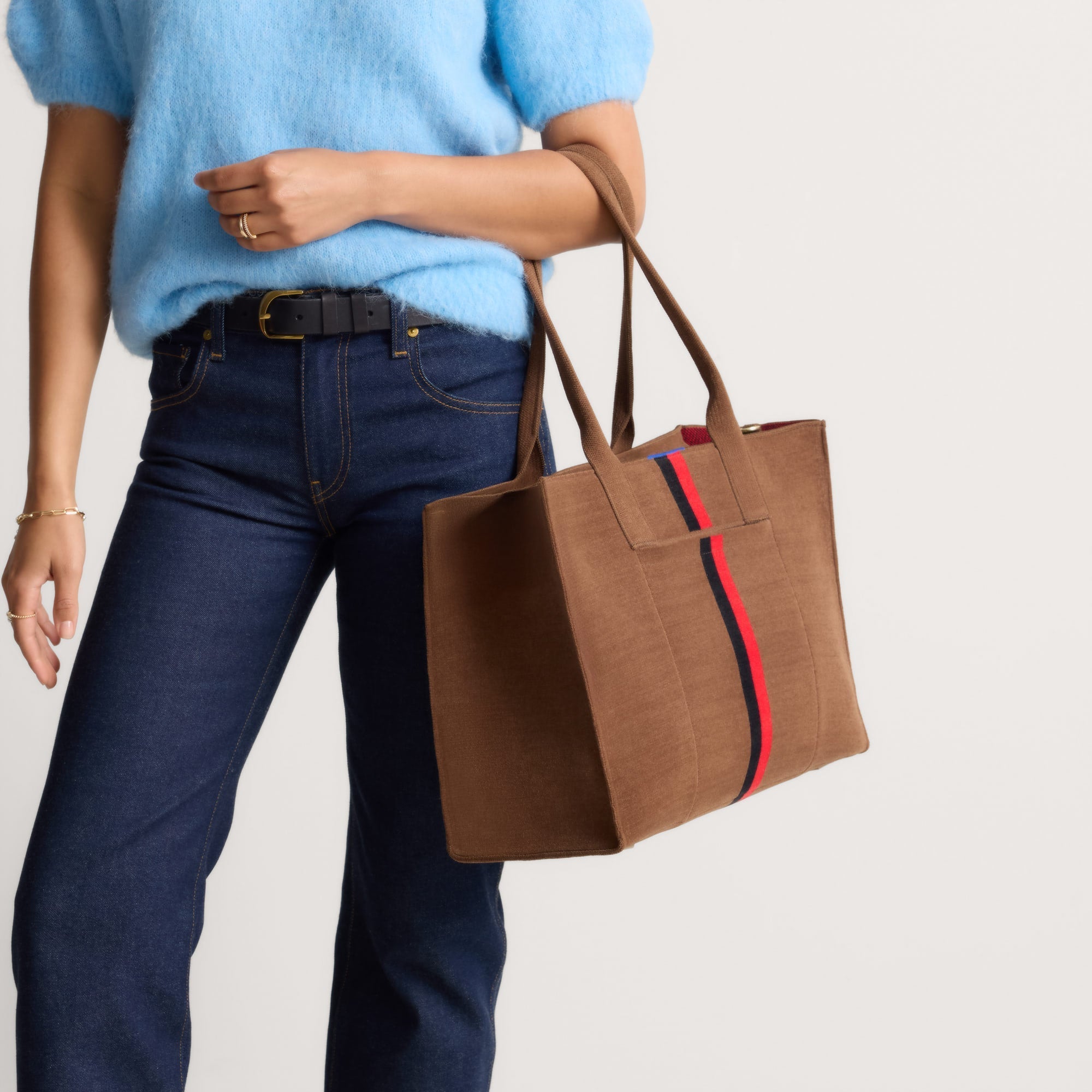 hover | The Classic Tote in ReVelvet Cinnamon Stripe, worn over the shoulder by a model, shown from the side.