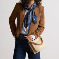 hover | The Daily Crossbody in Macadamia Open-Knit, carried over the shoulder of a female model, shown from the right.